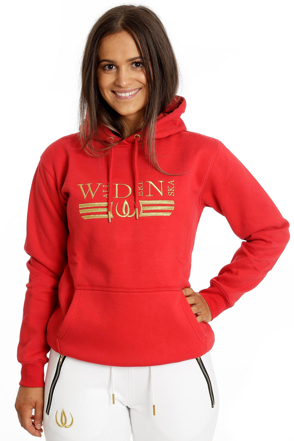 Le mannequin porte le hoodie rouge à broderie dorée et poche kangourou avec le Deluxe Joggers Blanc.