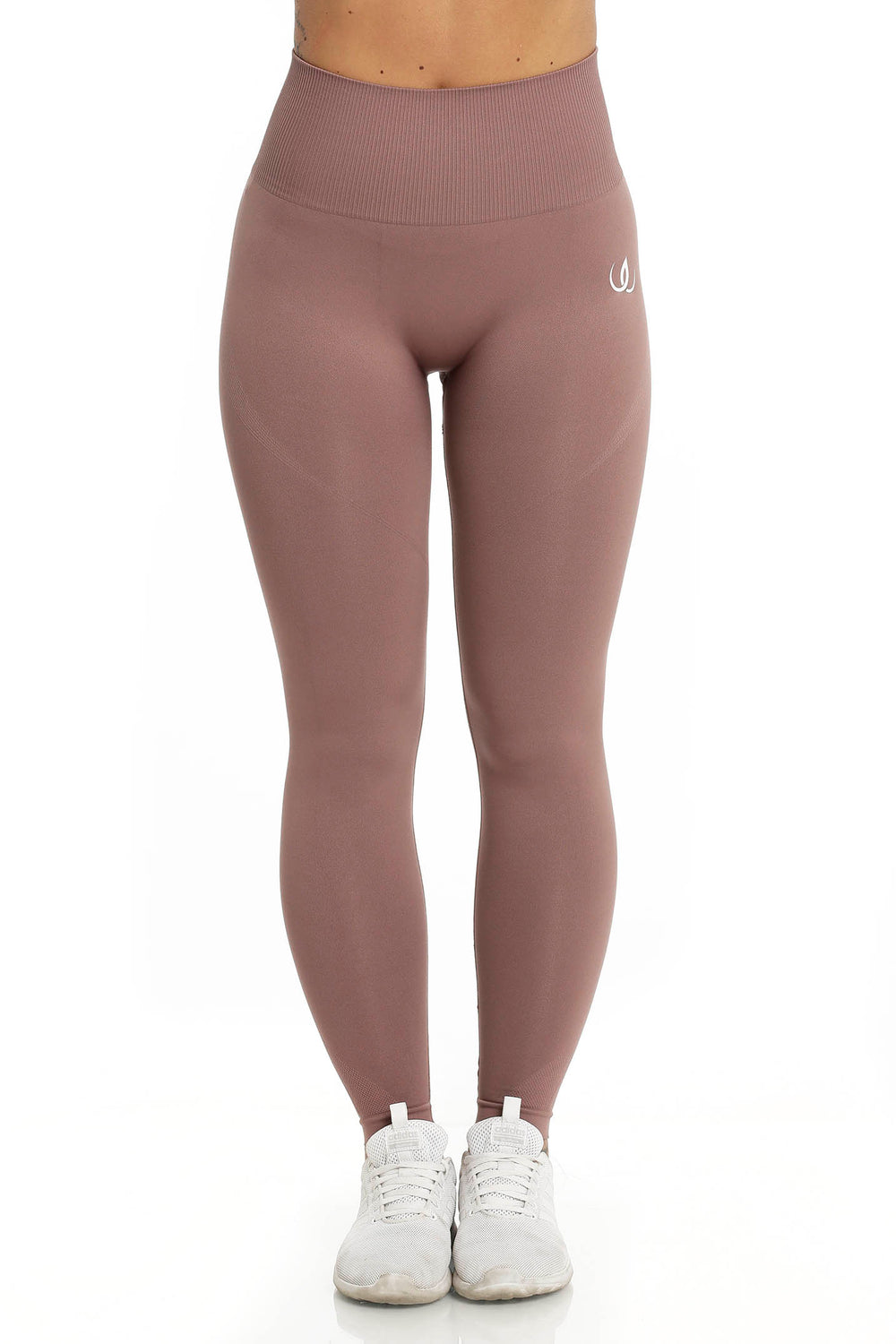 Un logo blanc se place à la hanche du legging brun rosé, la ceinture côtelée et haute.