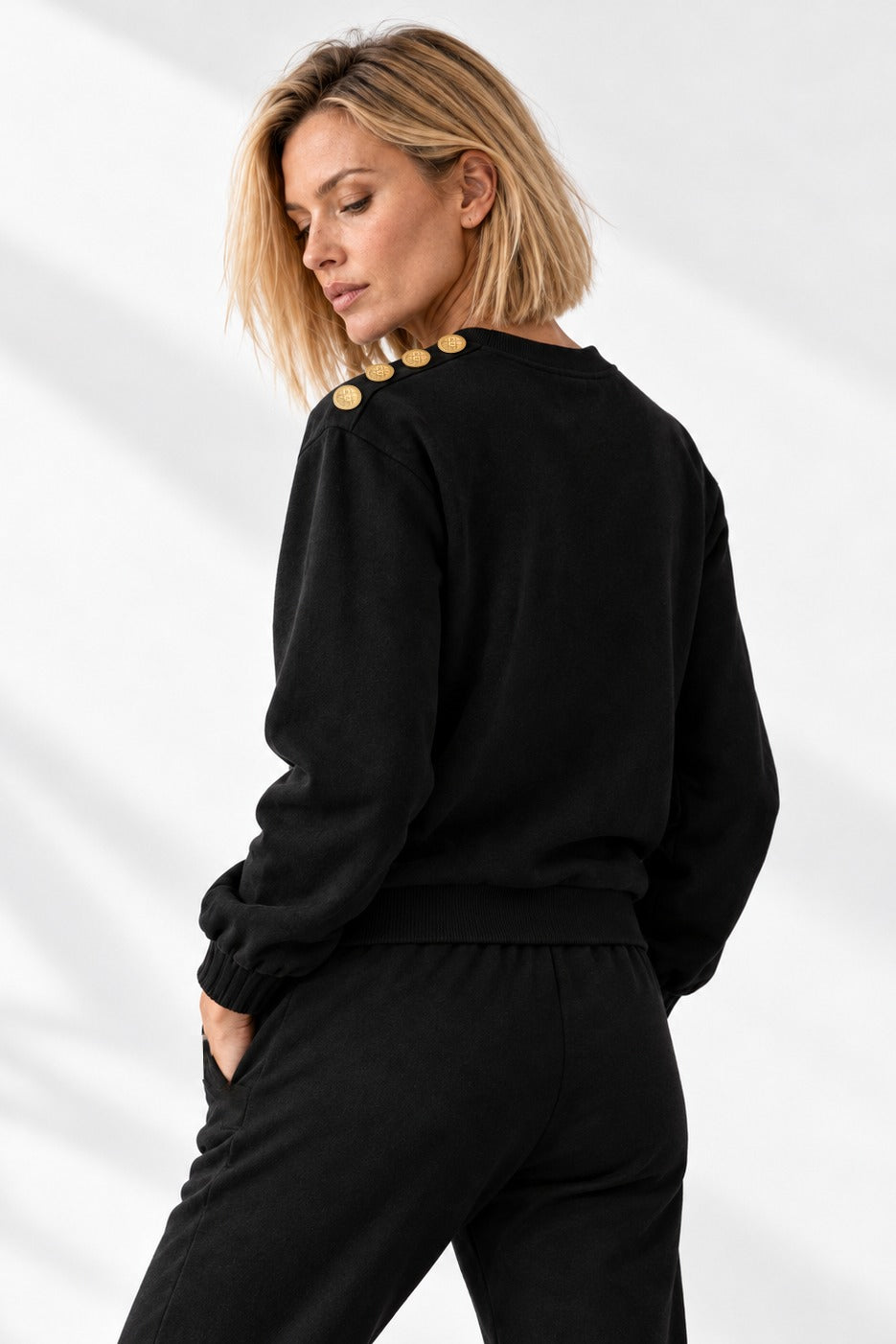 Pull Edge Gold Button de trois quarts dos, avec les boutons dorés le long de l'épaule.